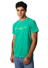 Man wearing a green t-shirt with a graphic design on a white background