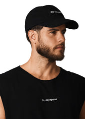 Man wearing a black cap and black t-shirt with text on a white background