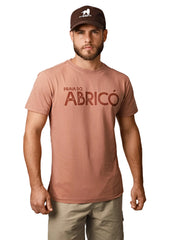 Man wearing a brown t-shirt with 'Praia do Abricó' text and a cap on a white background